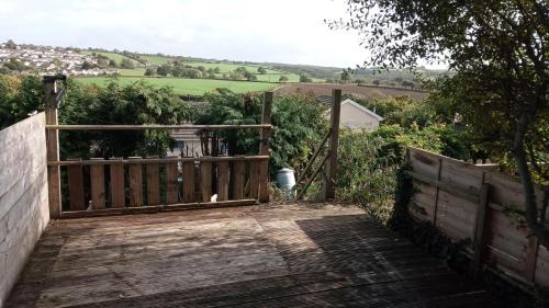 einen hölzernen Gehweg mit einem Tor und einem Zaun in der Unterkunft Rosemoor view. in Great Torrington