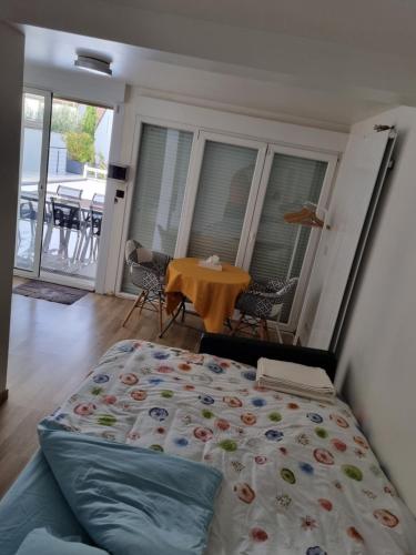 - une chambre avec un lit et une table avec des chaises dans l'établissement Ravissant Studio avec parking privé et jardin, à Rueil-Malmaison