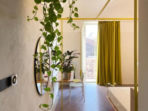 Cette chambre comprend une table avec des plantes et un miroir. dans l'établissement Zahara, à Catane