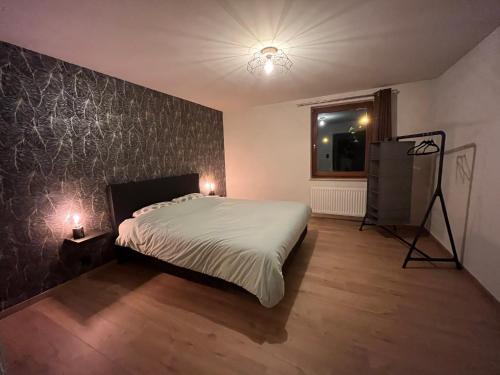 Gîte Chez Doumé في هوفاليز: غرفة نوم فيها سرير وتلفزيون