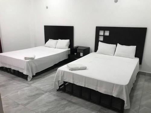 duas camas sentadas uma ao lado da outra num quarto em CASA DYA em Cozumel
