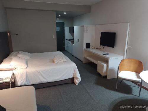 a bedroom with a bed and a desk and a television at Buenos Aires Apartamento in Buenos Aires