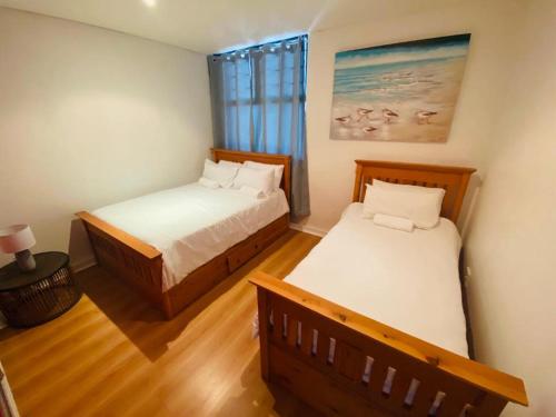 a bedroom with two beds and a window at The Waves, 806 Quayside Point Waterfront in Durban