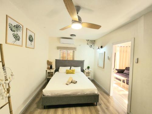 - une chambre avec un lit et un ventilateur de plafond dans l'établissement Sunshine Suite Boutique - Only 5 Min Walk To The Beach, à Eilat