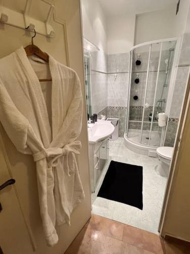 La salle de bains est pourvue d'un peignoir suspendu à la porte. dans l'établissement Rez-de-jardin sur la Promenade des Anglais, à Nice