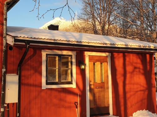 una casa roja con una ventana y una puerta en Funäsdalen Högen 6, en Funäsdalen