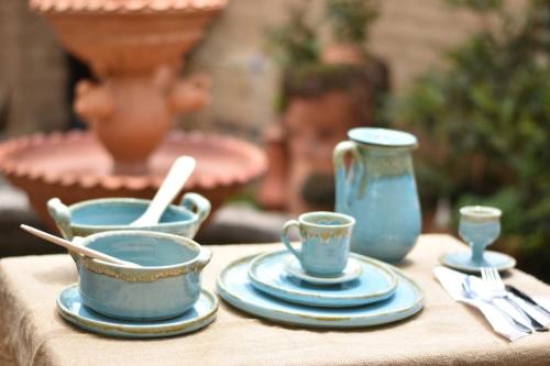 a table with blue cups and saucers on it at Posada El Artesano De Raquira in Ráquira
