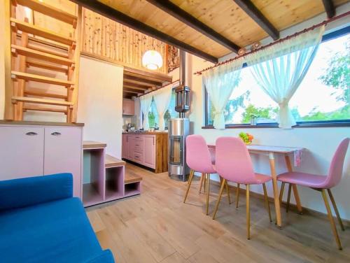eine Küche mit einem Tisch und rosa Stühlen in der Unterkunft Guitar House - Symphony Resort in Râșnov