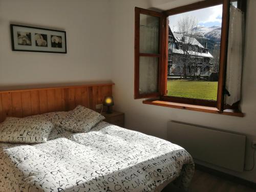 Schlafzimmer mit einem Bett und einem Fenster in der Unterkunft Apartaments Pleta Bona in Pla de l'Ermita