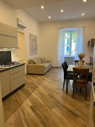 a kitchen and living room with a table and a couch at Casa D'Aria in Savona