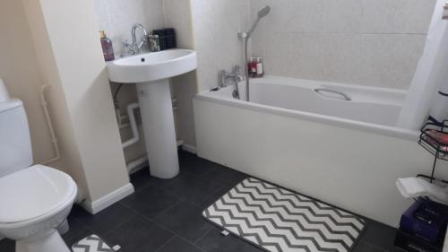 a bathroom with a sink and a tub and a toilet at Hamble Lounge - Accomodation for Aylesbury Contractors & Industrial estate - Free Parking & WIFI Sleeps up to 6 people in Buckinghamshire