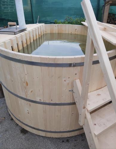 a wooden barrel with a pool of water at Sweet Home Apartman Szilvásvárad in Szilvásvárad