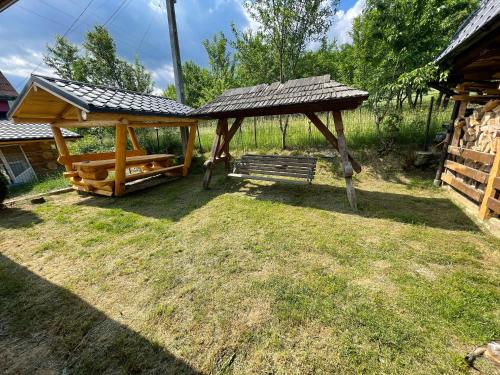 a wooden pavilion with a bench in a yard at Vila Deluț in Borşa