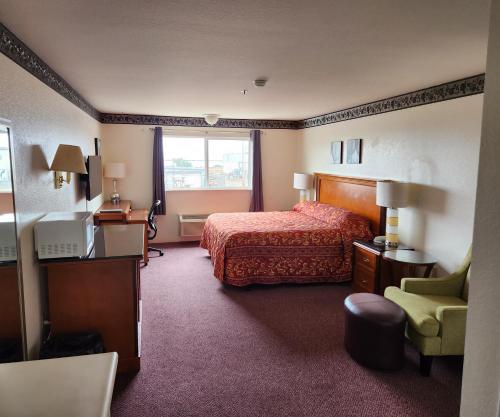 Bayview Inn في كريسنت سيتي: غرفه فندقيه بسرير ونافذه