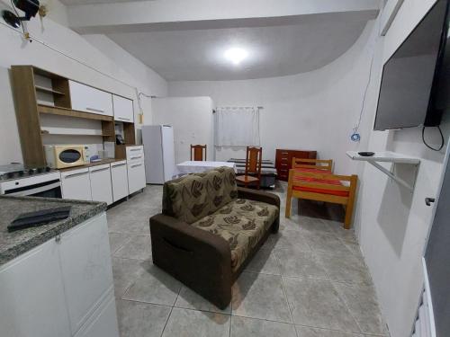 sala de estar con sofá y cocina en Kitnet de Inês, en Itanhaém