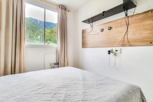 1 dormitorio con cama blanca y ventana en Apartamentot perfeito, aconchegante e com Clube, en Río de Janeiro