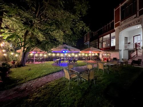 a group of tables and chairs in a yard at night at Hotel Canteklaar in De Haan