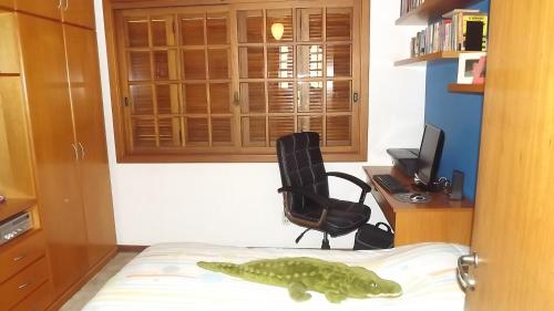 a bedroom with a dinosaur on the bed and a desk at Alugo quarto com internet in Porto Alegre