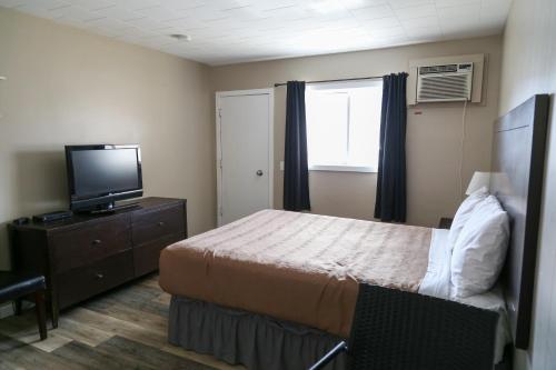 a hotel room with a bed and a television at Richter Pass Beach Resort in Osoyoos