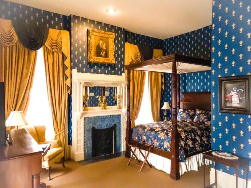 um quarto com uma cama de dossel e uma lareira em The Guest House Historic Mansion em Natchez