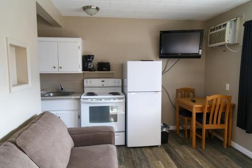 a kitchen with a refrigerator and a couch and a table at Richter Pass Beach Resort in Osoyoos