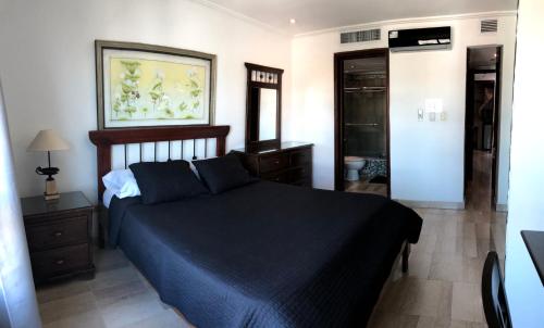 una camera con letto e piumone blu di Malecon Center a Santo Domingo