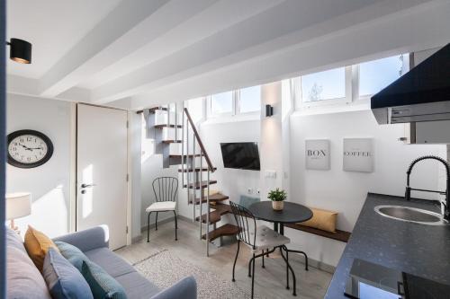 a living room with a staircase and a table and chairs at FLH Beato Lofts in Lisbon