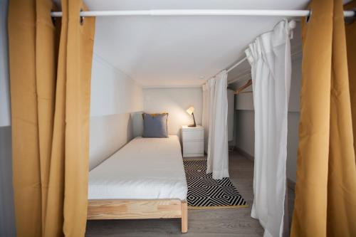 a bedroom with a bed in a room with curtains at FLH Beato Lofts in Lisbon