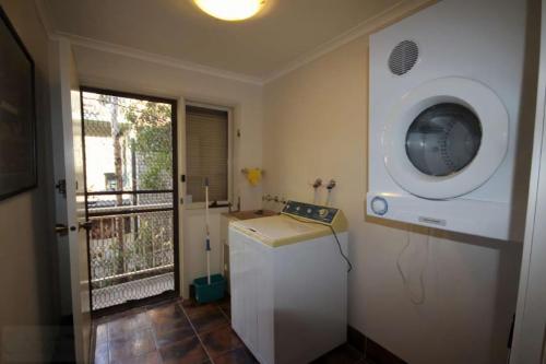 a small room with a washing machine and a balcony at Hearthstone in Blackheath