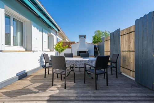 un patio avec une table et des chaises sur une terrasse dans l'établissement maison chaleureuse, au Château-dʼOléron