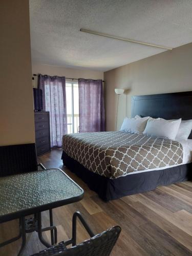 a hotel room with a bed and a table at Richter Pass Beach Resort in Osoyoos