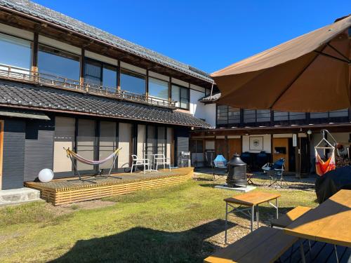 a building with a patio with a hammock in front of it at HIKE in Nirasaki