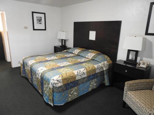 a hotel room with a bed and a chair at Downtown Inn in Albuquerque