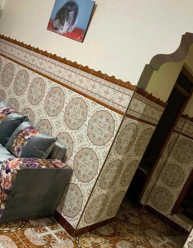 Bett in einem Zimmer mit einer gefliesten Wand in der Unterkunft Dar Abdlouahed in Chefchaouen