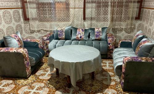 ein Wohnzimmer mit einem Sofa, einem Tisch und Stühlen in der Unterkunft Dar Abdlouahed in Chefchaouen