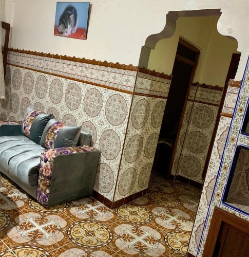 - un canapé dans une pièce dotée d'un mur en carrelage dans l'établissement Dar Abdlouahed, à Chefchaouen