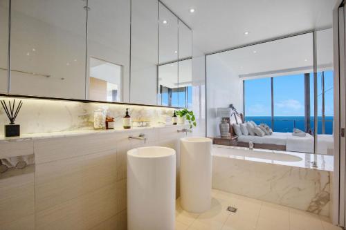 un bagno con vasca e un grande specchio di Sub Penthouse Oracle 46th floor - GC Getaways a Gold Coast