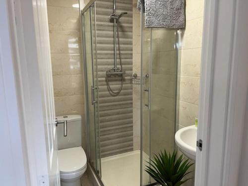 a bathroom with a shower with a toilet and a sink at Lovely 2 Bedroom 2 Bathroom Apartment with Parking in Loughborough