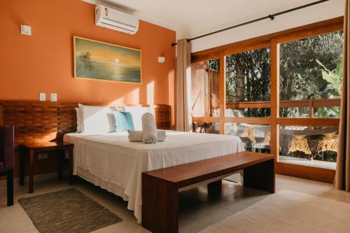 a bedroom with a bed and a large window at Pousada Todas as Luas in Ubatuba