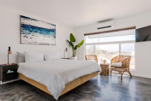 a bedroom with a large bed and a large window at Desert Hot Springs Inn in Desert Hot Springs