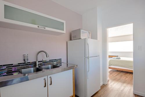 a kitchen with a sink and a refrigerator at Desert Hot Springs Inn in Desert Hot Springs