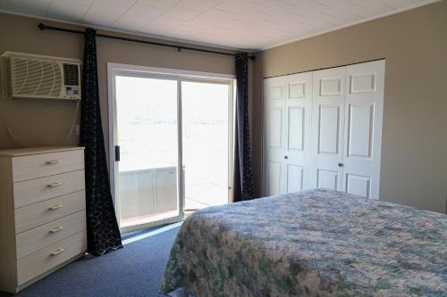 a bedroom with a bed and a large window at Richter Pass Beach Resort in Osoyoos