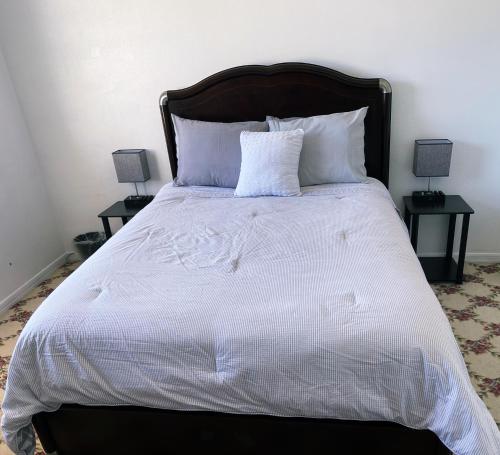 un grande letto con lenzuola e cuscini bianchi di Hello Sunshine 321... Lift Off a Titusville