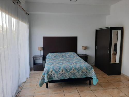 ティグレにあるHermoso departamento en complejo residencialのベッドルーム1室(青い毛布と鏡付きのベッド1台付)