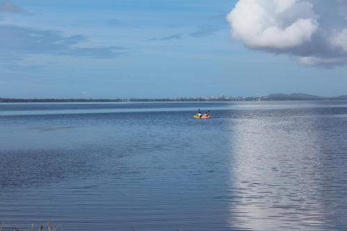 two people in a boat on a large body of water at Tuggerah lakefront 4 bed 2 bath home with stunning views in Gorokan