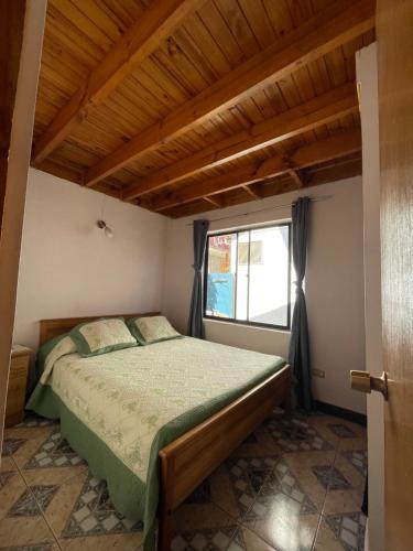 a bedroom with a bed and a window at Cabañas Las Palmeras Pichilemu in Pichilemu
