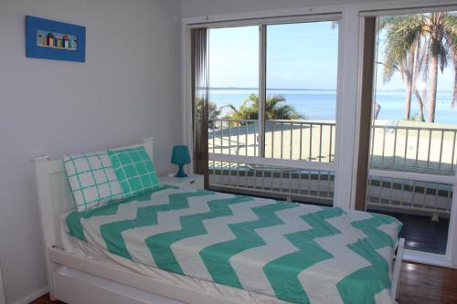 1 dormitorio con 1 cama y vistas al océano en Stunning lakefront 4-bedroom, 2.5-bath home en Gorokan
