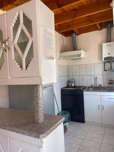 a kitchen with a sink and a counter top at Cabañas Las Palmeras Pichilemu in Pichilemu