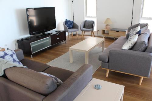 sala de estar con 2 sofás y TV de pantalla plana en Stunning lakefront 4-bedroom, 2.5-bath home en Gorokan
