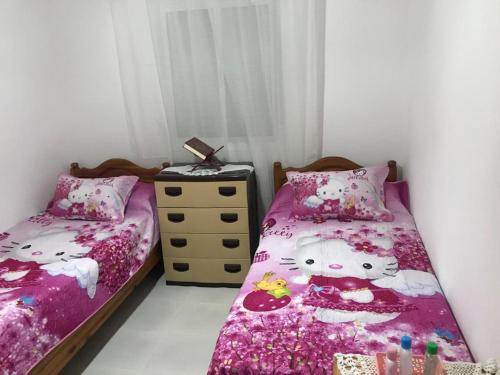 a bedroom with two beds with hello kitty sheets at Appart bades 